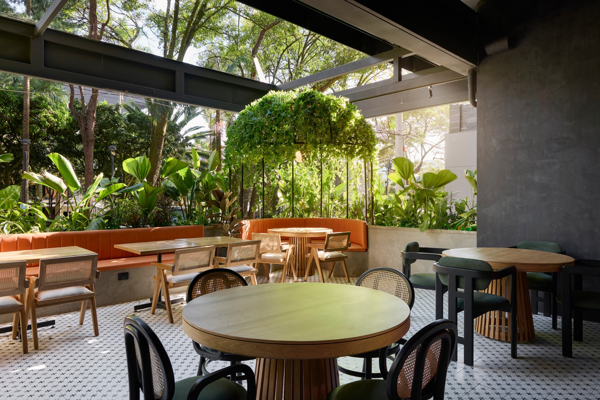 Terraza con banca naranja y plantas en Amelier Café