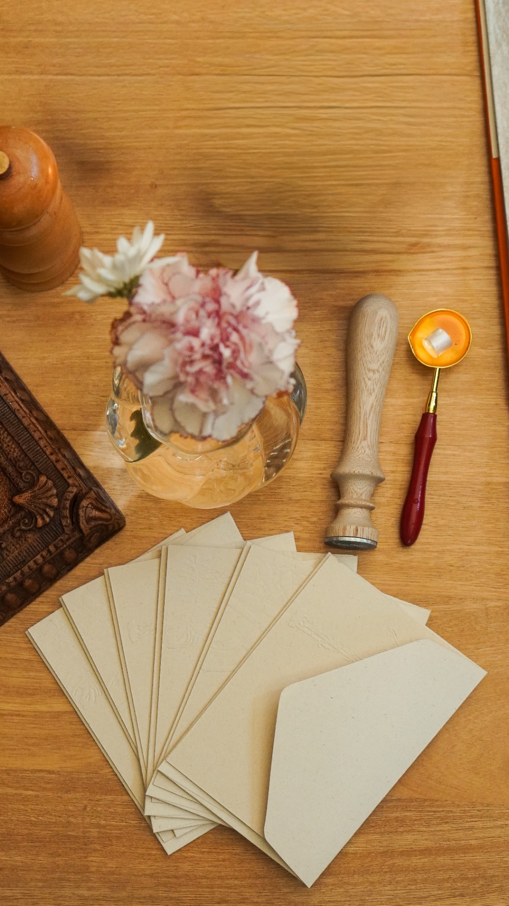 Detalle de papelería y flores sobre mesa de madera en Amelier Poblado